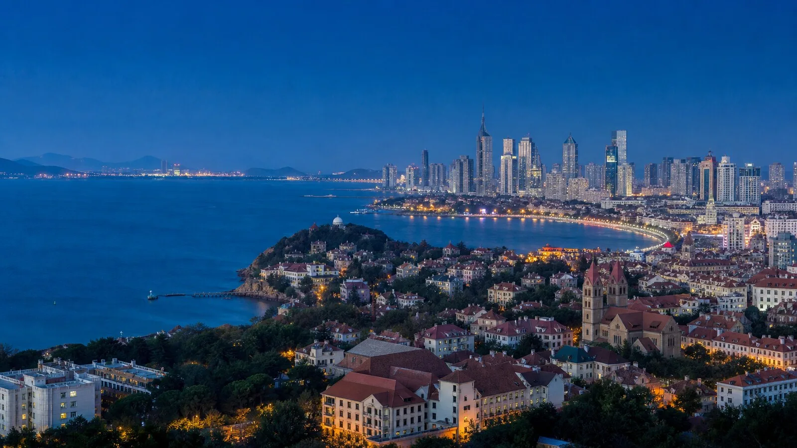 青岛海岸城市天际线红瓦建筑与蓝色海湾景观